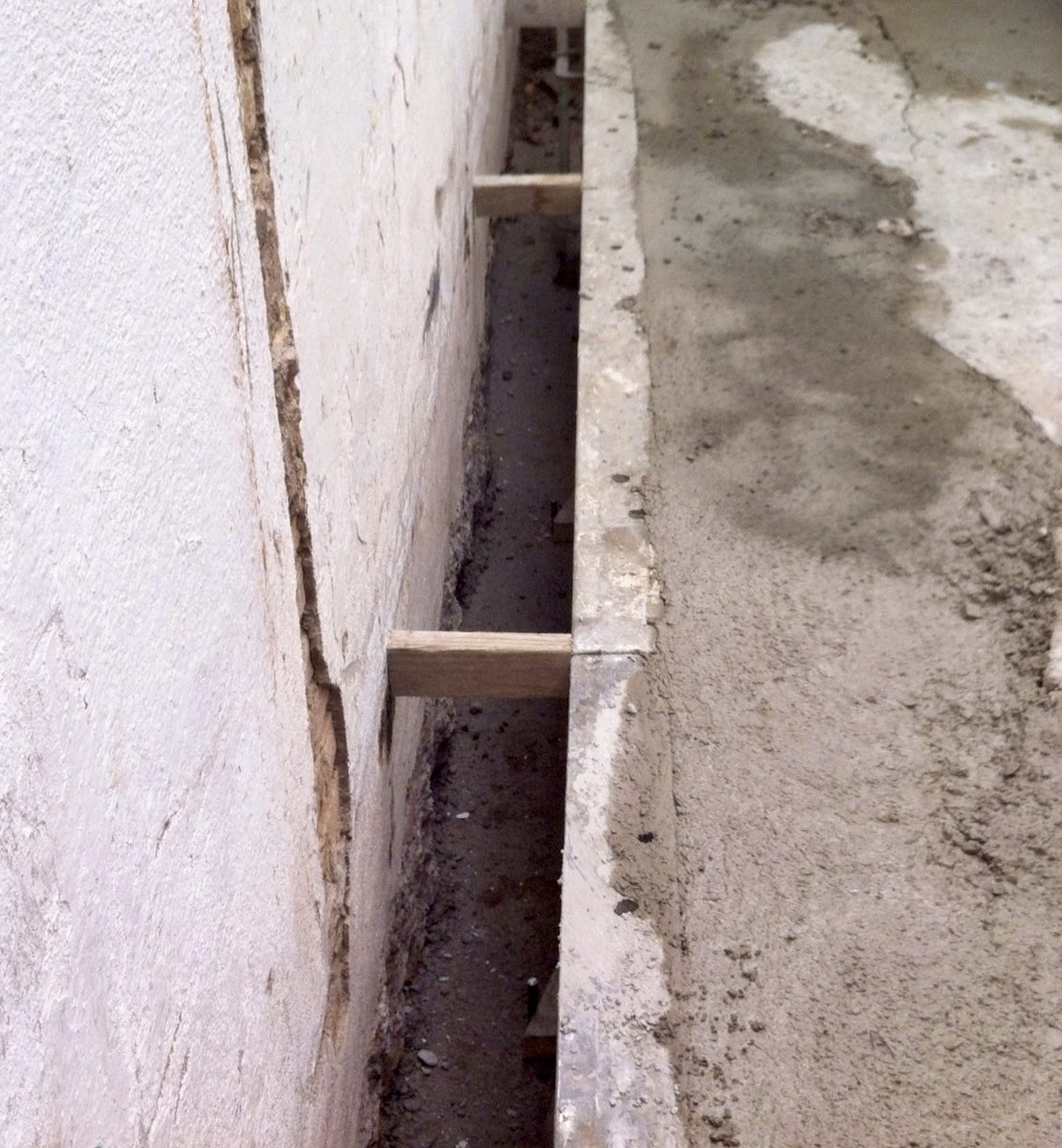 Panel de muro pantalla de pequeño espesor junto a estructura existente.